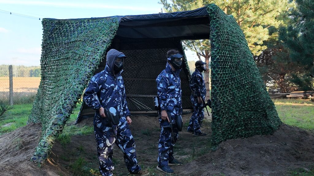 Grupa graczy w maskach podczas dynamicznej gry paintballowej w Kozbifield w Busku