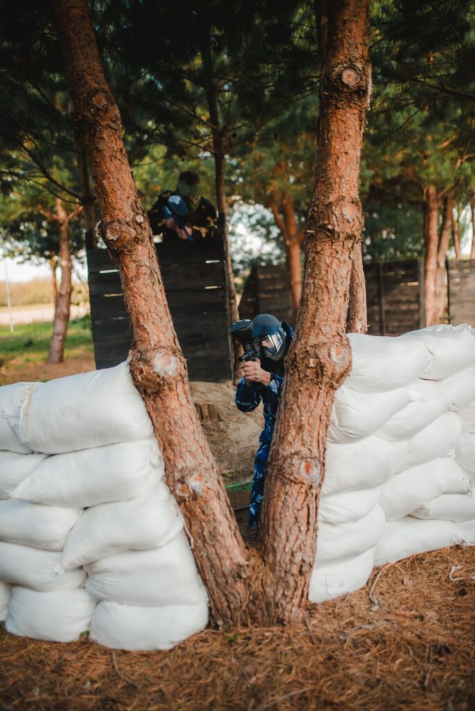 Gracz skradający się w lesie podczas rundy paintballowej w Kozbifield – taktyczne podejście